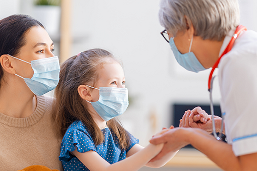 Image of provider holding hands and meeting with pediatric patient