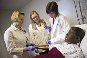 Participating in a training exercise in the simulation lab are Division of Education staff members (from left) Suzanne Moertl, Amanda Hodd and Amy Kadlecek.