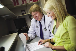 Michael McManus, M.D., and Nicole Kattre, clinical research coordinator, review reports for clinical research trials.