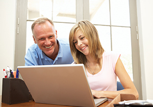 Dad and daughter looking at computer