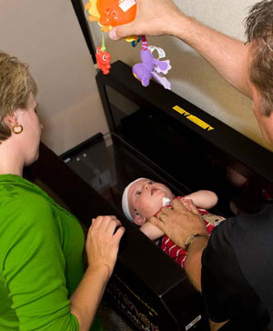 Michelle Axford watches as her son Tyler has his cranial shape measurement taken by Gary Ovaska.The STARscanner™ laser scanner has been used for a year and one-half in the Orthotics Department, thanks to a generous donation from Children's Miracle Network.