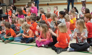 The Kindergarten students at Grant Elementary, dressed in orange toshow their support of Will’s battle with leukemia, gather in the gym topresent their donation to Marshfield Clinic. 