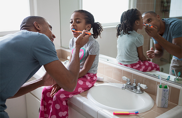 Young girl having teeth brushed.