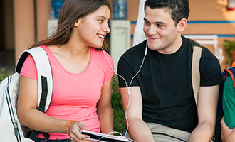 boy and girl share earbuds listening to music