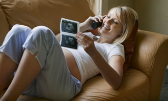 woman talking on phone looking at ultrasound picture