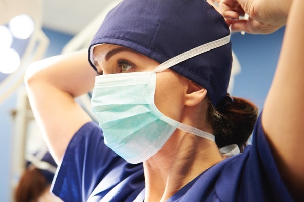 Image of Marshfield Clinic doctor putting on a clotch mask